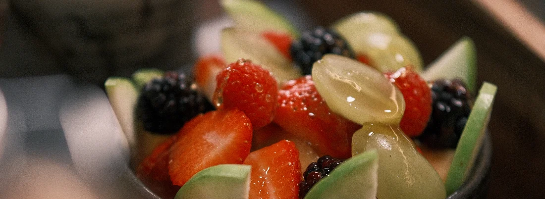 Fresh fruit bowl with berries, grapes and kiwi